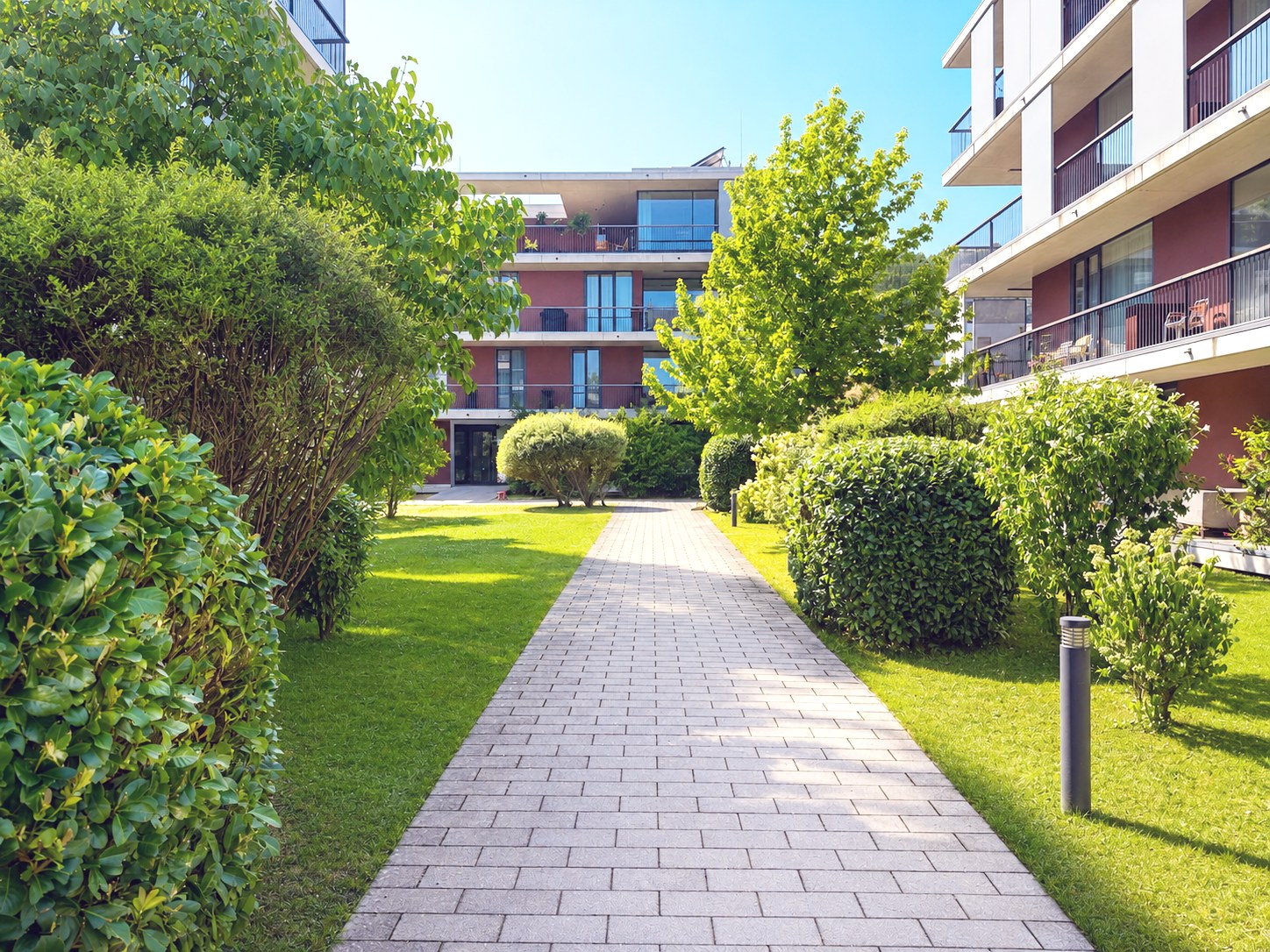 Gartenhof der Anlage mit Wegen und Heckenpflanzung